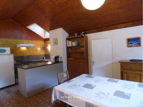 une cuisine avec une table et un comptoir dans l'établissement Duplex 3 pièces avec balcon, proche village et remontées - 6 pers - FR-1-458-165, au Grand-Bornand
