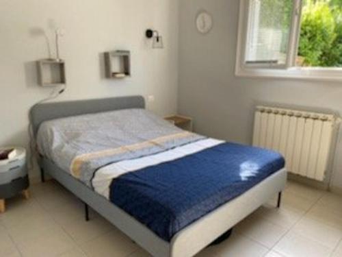 une chambre avec un lit avec une couverture bleue dans l'établissement Appartement pieds dans l'eau à Royan avec jardin et équipements complets - FR-1-494-130, à Royan