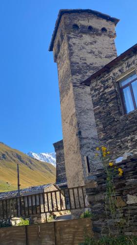 a stone building with a window and a fence at Nizharadze's Tower in Ushguli