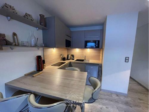une cuisine avec une table et des chaises dans une pièce dans l'établissement Studio rénové 1er étage pour 4 pers. - Le Grand-Bornand - FR-1-458-182, au Grand-Bornand