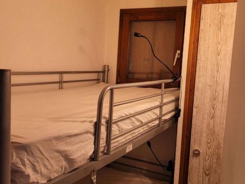 - un lit superposé vide dans un dortoir avec une porte dans l'établissement Studio rénové avec cabine pour 4 pers, calme à Le Grand-Bornand - FR-1-458-199, au Grand-Bornand