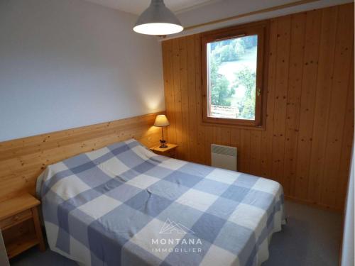 ein Schlafzimmer mit einem blauen und weißen Bett in einem Zimmer in der Unterkunft Appartement Le Grand-Bornand, 2 pièces, 4 personnes - FR-1-458-189 in Le Grand-Bornand