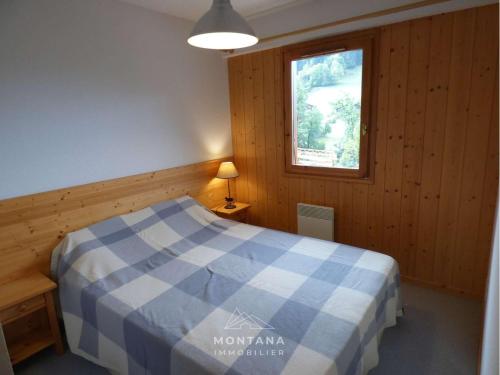 une chambre avec un lit bleu et blanc dans une pièce dans l'établissement Bel appartement 4 pers. avec balcon et garage au Grand-Bornand - FR-1-458-189, au Grand-Bornand