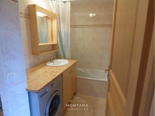ein Badezimmer mit einem Waschbecken und einer Waschmaschine in der Unterkunft Appartement Le Grand-Bornand, 2 pièces, 4 personnes - FR-1-458-189 in Le Grand-Bornand