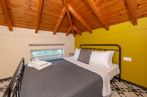 un letto in una camera con parete gialla di Spedion Villa a Gythio