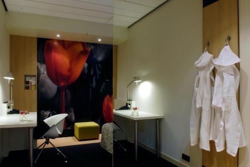 a dressing room with white clothes hanging on a wall at Mercure Hotel Schiphol Terminal in Schiphol
