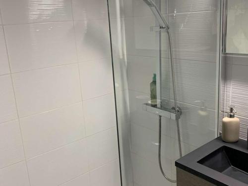 une douche avec une porte vitrée à côté d'un lavabo dans l'établissement Studio rénové 4 pers, Le Grand-Bornand, balcon sud, proche skibus - FR-1-458-200, au Grand-Bornand