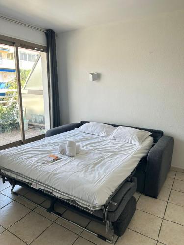 - un lit dans une chambre à côté d'une fenêtre dans l'établissement Résidence Graziella Studio 606, à Juan-les-Pins