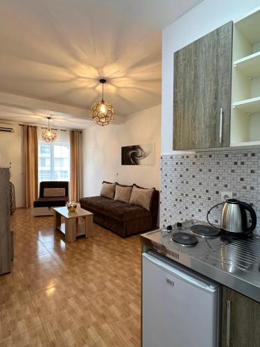 a kitchen and a living room with a couch at Apartmens Xhenis Lux in Ulcinj