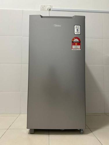 a metal refrigerator sitting in a room at Kuala Selangor 16pax, Karaoke ,End lot 3 Storey in Bukit Rotan