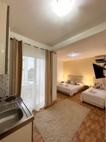 a kitchen with two beds and a sink in a room at Apartmens Xhenis Lux in Ulcinj