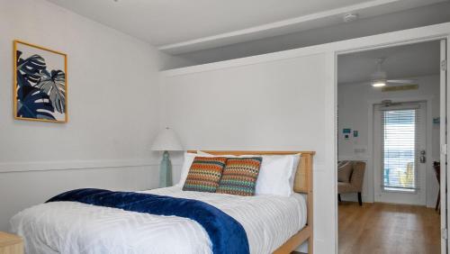 een slaapkamer met een bed met een blauwe en witte deken bij Sunset Beach House - Beach Hugger 3 in St Pete Beach