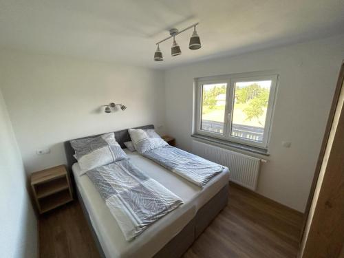 um quarto com uma cama e uma janela em Erlebnisbauernhof Pension Waschnig em Sankt Kanzian
