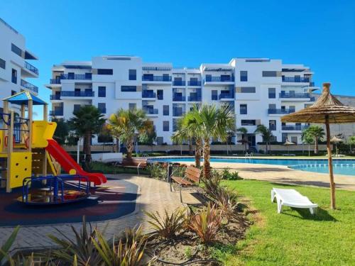 Résidence de Luxe avec Piscine à Costa Mar Playa في مرتيل: ملعب أمام مبنى كبير به حمام سباحة