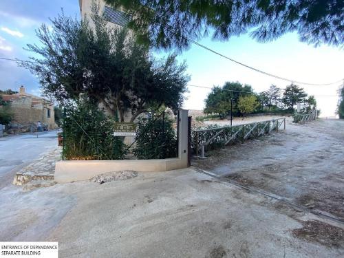 a fence on the side of a street with a tree at Tenute Plaia Agriturismo in Scopello