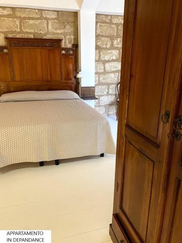 a bedroom with a bed and an open door at Tenute Plaia Agriturismo in Scopello