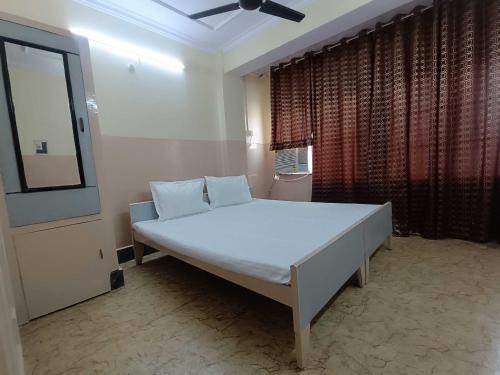 a large white bed in a room with a window at Hotel O Nitya in Ayodhya