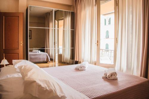 a bedroom with a white bed with towels on it at Casa Paolina in Lucca