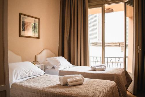 a hotel room with two beds and a window at Casa Paolina in Lucca