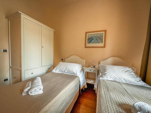 a bedroom with two beds and a cabinet at Casa Paolina in Lucca