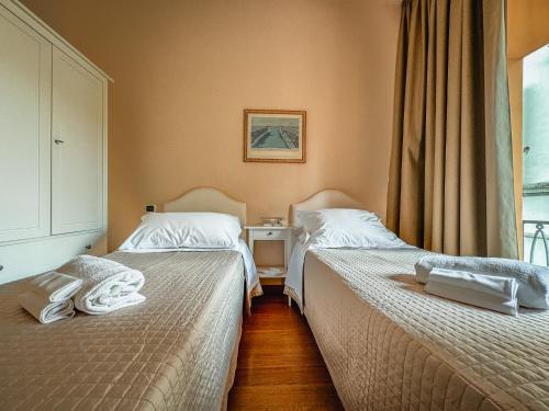 two beds in a hotel room with towels on them at Casa Paolina in Lucca