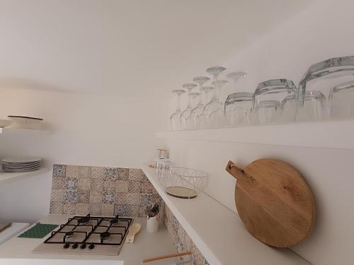 eine Küche mit einer Theke mit Gläsern an der Wand in der Unterkunft LA PERLA, comfort e relax in Vignacastrisi