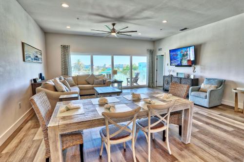 a dining room and living room with a table and chairs at Madeira Del Mar Penthouse #2- Premier in St. Pete Beach