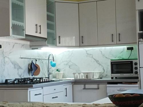 a kitchen with white cabinets and a counter top at Villetta da Carla in Castelló d'Empúries