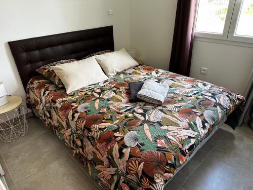 - une chambre avec un lit doté d'une couverture et d'oreillers colorés dans l'établissement Gîte en Drôme Provençale, à Espeluche