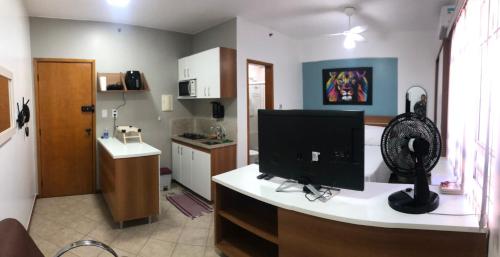 cocina con escritorio y monitor de ordenador en Flat Luxo 5* centro: Seu Sonho esta aqui!, en Brasilia