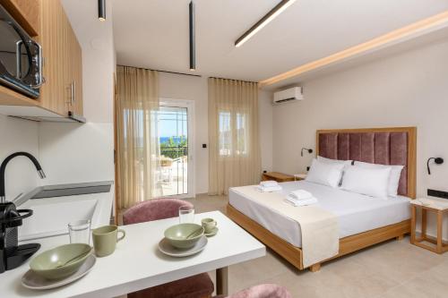 a bedroom with a bed and a table and a kitchen at Fotini Studios in Chrysi Ammoudia