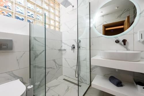 a bathroom with a shower and a sink and a mirror at Fotini Studios in Chrysi Ammoudia