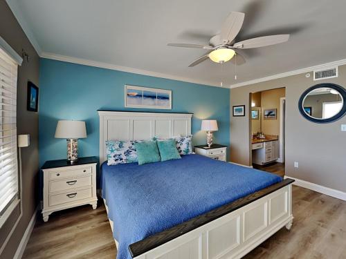 a bedroom with a bed and a ceiling fan at Sea Winds 904 in Ormond Beach