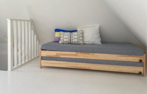 a bed with pillows on it in a room at Awesome Home In Limhamn With Kitchen in Malmö