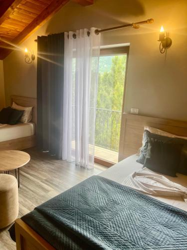 a bedroom with a bed and a large window at Hotel Kulla e Arte in Razëm