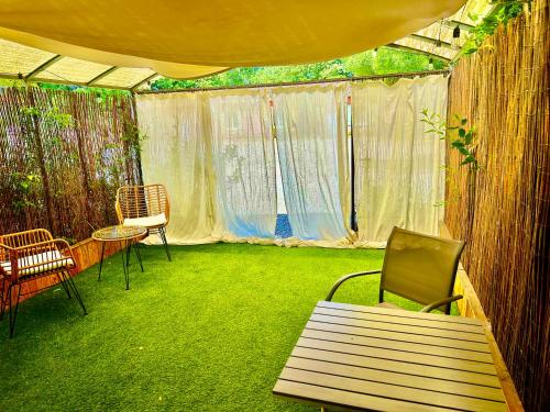 a patio with chairs and a table and a tent at Domaine Plan des Devens in Roussillon
