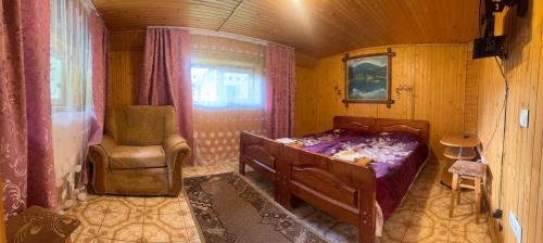 Верховинський водограй في سينيفيرسكا بوليانا: غرفة نوم بسرير وكرسي في غرفة