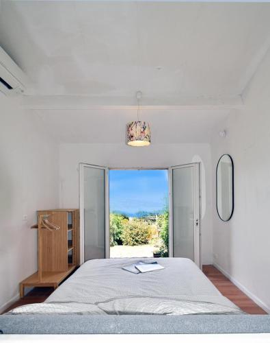 une chambre avec un grand lit et une fenêtre dans l'établissement Piscine chauffée et magnifique vue mer! à10 mns de la plage & du centre!, à Cavalaire-sur-Mer