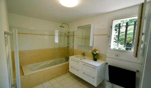 une salle de bain avec une baignoire et un lavabo et une baignoire dans l'établissement Piscine chauffée et magnifique vue mer! à10 mns de la plage & du centre!, à Cavalaire-sur-Mer