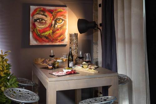 a table with food and wine glasses and a painting at Bel Horizon in Le Chambon-sur-Lignon