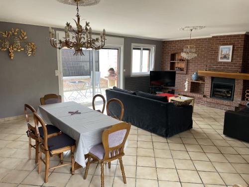 a living room with a table and chairs and a couch at Maison coeur des Weppes La Maralbique in Wavrin