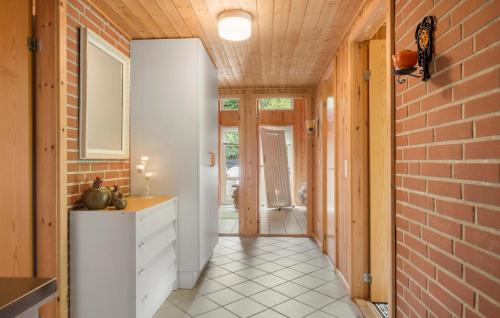 a kitchen with a white cabinet and a brick wall at Stunning Home In Brovst With Sauna in Brovst