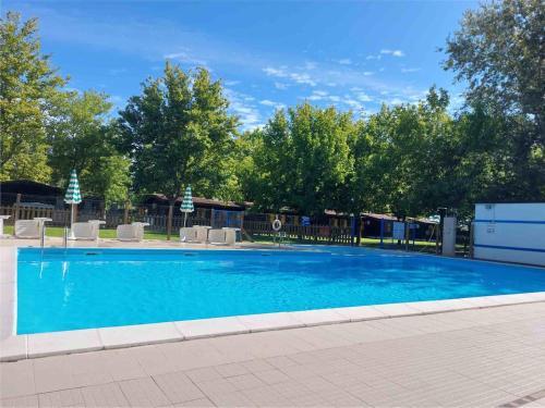 una gran piscina azul con sillas y árboles en Villaggio Samoa en Lido delle Nazioni