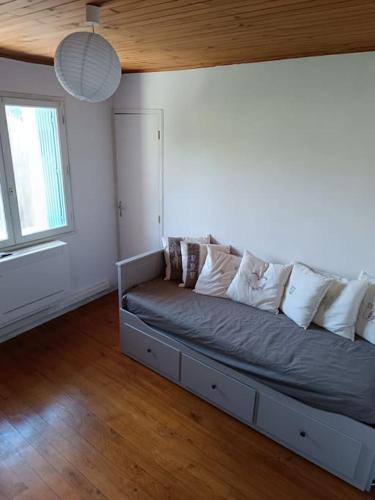 un canapé avec des coussins dessus dans un salon dans l'établissement Maison cœur de village 300 m des gorges du gardon, à Collias