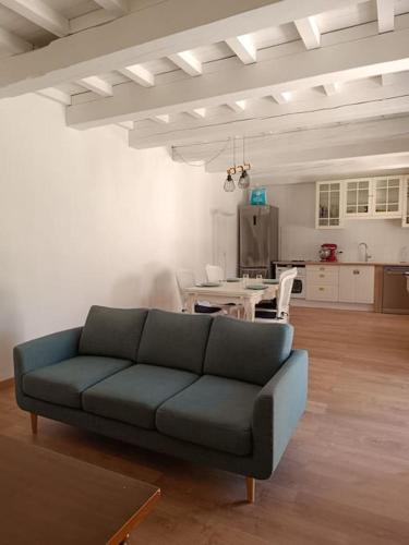 un salon avec un canapé bleu et une table dans l'établissement Maison cœur de village 300 m des gorges du gardon, à Collias