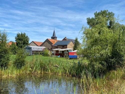 a building next to a river with a church at Bungalow accueillant à Saint-Pardoux avec piscine partagée in Saint-Pardoux