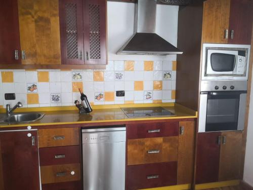 a kitchen with a sink and a stove top oven at Casa Umbría in Valsequillo