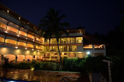 a hotel at night with a pool in front of it at Aadisaktthi Leisure Resort, Kovalam in Trivandrum
