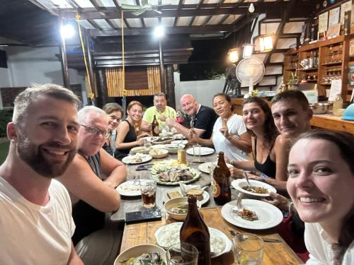 een groep mensen die rond een tafel zitten met eten bij CASA MIA INN in Dauis