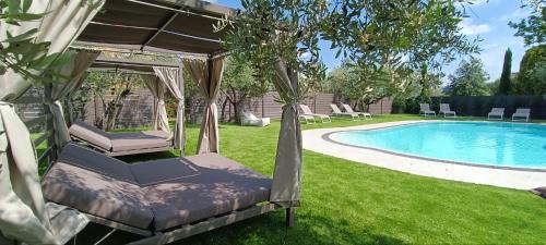 einen Pool im Garten mit Hängematte neben einem Pool in der Unterkunft Hotel Confine in Colà di Lazise